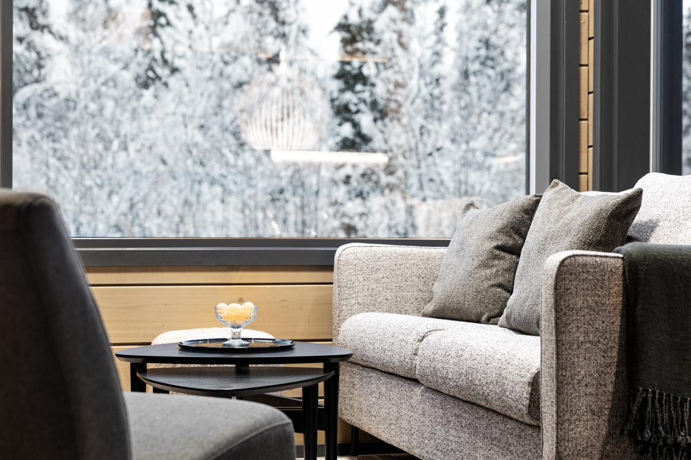 Zithoek met design loungebank en uitzicht op het besneeuwde bos